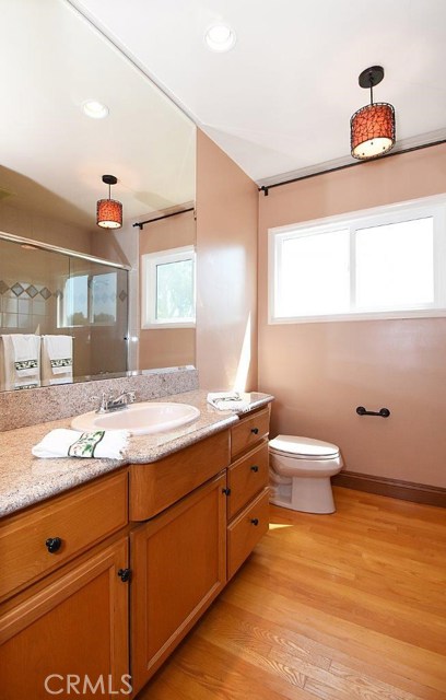 Remodeled hall bathroom with beautiful cabinets and refinished wood floors