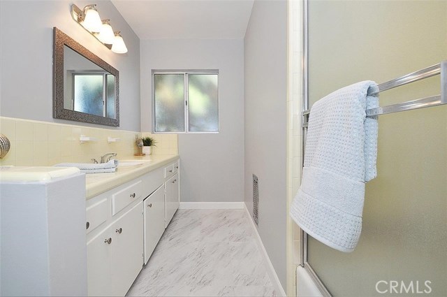 Main bathroom with tub/shower, freshly painted with new mirror, lighting, knobs and flooring.