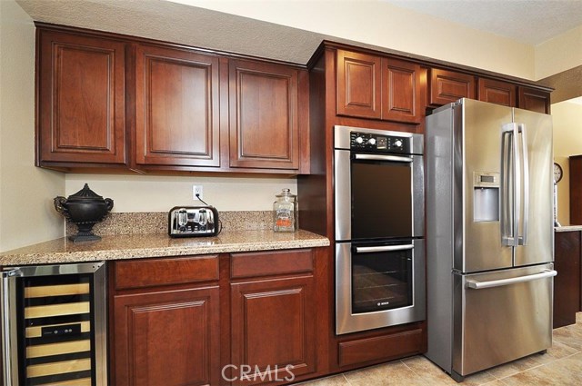 Wall of kitchen which includes Bosch refrigerator, Bosch double ovens & the wine cooler