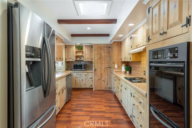 The spacious galley style kitchen has solid wood cabinetry and classic tile work - embrace the timeless style or customize to you own design.