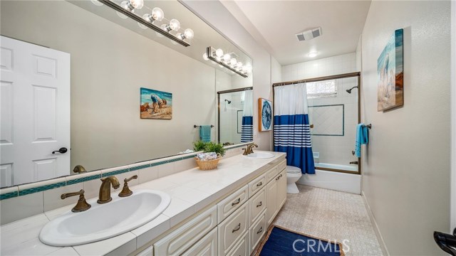 Downstairs full bath with dual sinks.