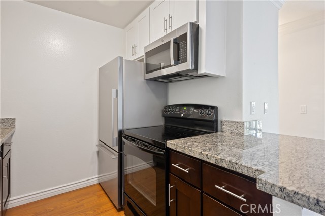 New refrigerator and microwave with upgraded countertop and cabinets.