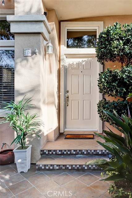 Beautifully tiled steps and manicured landscape elevates this front entry.