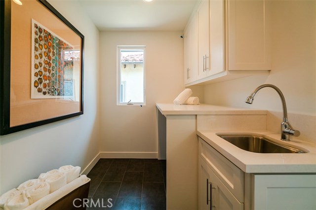 Upstairs utility room with sink, counters and tons of cabinet space.