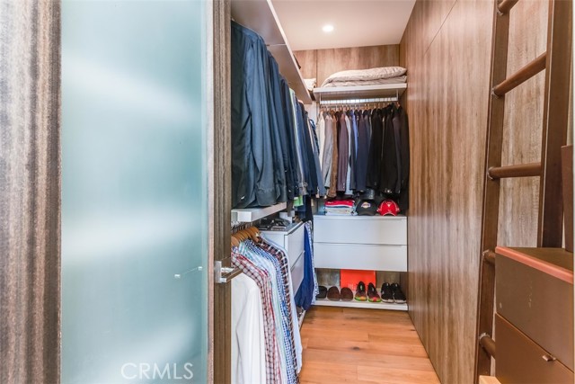 Beautiful primary suite walk-in closet with a sleek and sophisticated design