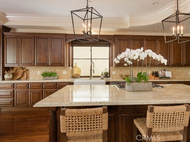 Kitchen has recessed lighting and three chandeliers.