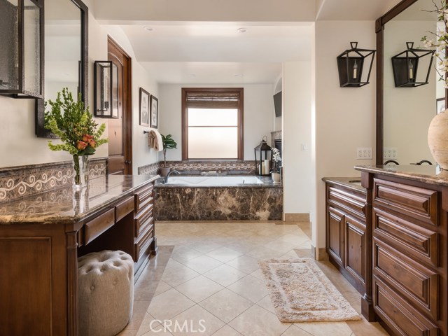 Large jetted tub with fireplace and TV.