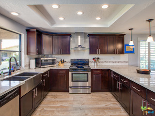 open concept kitchen with Caesarstone counters, stainless steel appliances and laminate floors