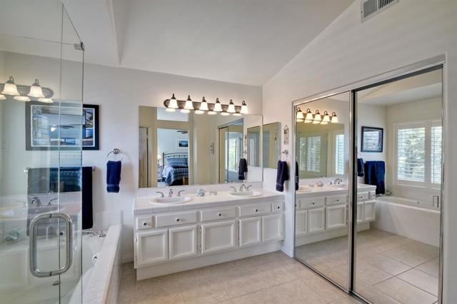 Large master bath with dual sinks and walk in closet with mirrored doors