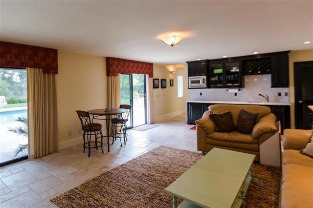 downstairs rec room with kitchenette view  refrigerator behind louvered door