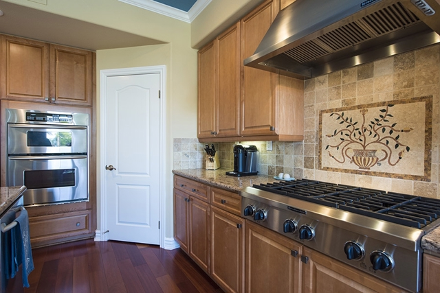 This kitchen includes top of the range Kitchen Aide appliances with a large island for gatherings.