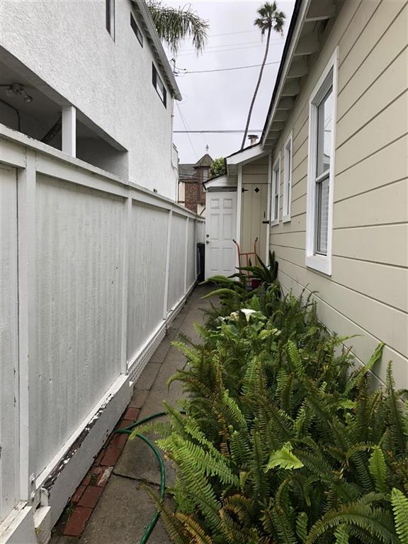 East side of house looking south towards front of home. Water heater closet and gate leading to front driveway.