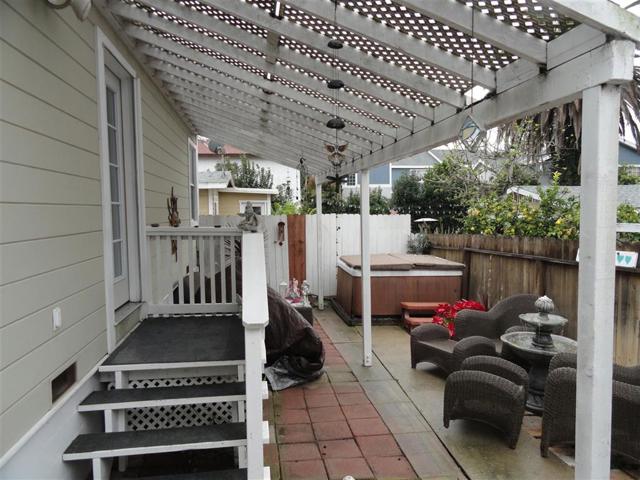 Fenced-in back patio looking west with hot tub and plenty of room entertaining.