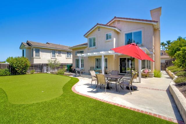 Open yard with lattice patio cover is perfect for all your entertaining needs- complete with putting green!!!