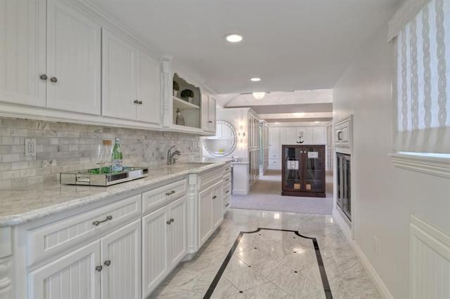 Wet bar and wine refrigerator with light up vanity in the master closet