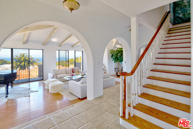 A grand entrance to tall wood beamed ceilings and ocean views