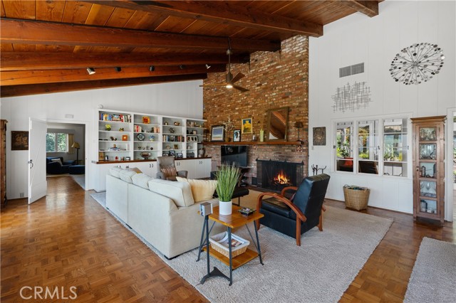 The living room is anchored by the large brick fireplace.