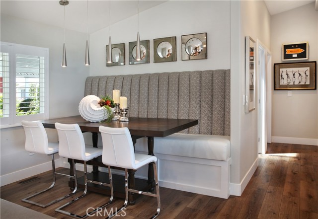 Built in seating in dining area and view into hallway towards secondary bedrooms and full bath with walk-in shower.