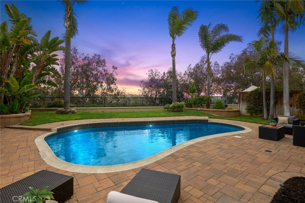 VIEW HOME, TROPICAL BACKYARD WITH POOL, 3 BEDROOMS + AN OFFICE/RETREAT AND IN MARINA HILLS! Perfectly situated at the end of a cul-de-sac, on the view side of the street, on a private lot, with southern facing exposure and an incredible backyard with resort style pool! Through a gated courtyard, enter to high ceilings, lots of natural light, fresh new paint, neutral colors and a serene indoor-outdoor atmosphere. A gourmet kitchen with stone counters, stainless steel appliances, ample cabinet and countertop space, bar stool seating and open to the family room, with both areas overlooking a serene backyard setting. Living room and dining room offer large spaces and are perfect for entertaining. Upstairs are 3 bedrooms with an additional bedroom retreat which could be multi-purpose or possibly converted to a 4th bedroom. The primary bedroom is highlighted with vaulted ceilings, panoramic hillside views and ocean breezes. The upgraded primary bathroom includes an enlarged shower with rain shower head, stone countertops, counter-mounted glass sinks, upgraded cabinetry and hardware. Also on the second floor are 2 secondary bedrooms and a full bath with dual sinks. Wood floors run throughout most of the main floor and the upstairs hall. The driveway and backyard are upgraded with pavers seamlessly throughout for an upscale aesthetic. Low HOA and no Mello-Roos. Enjoy access to Marina Hills resort style amenities with a jr olympic size swimming pool, wader and spa, showers, clubhouse with full kitchen and fireplace, tennis and pickleball courts, parks and tot lot within the community and walking path to Salt Creek Trail for a leisurely 4 mile walk or e-bike ride to Salt Creek Beach. The perfect coastal style pool home in an ideal location!