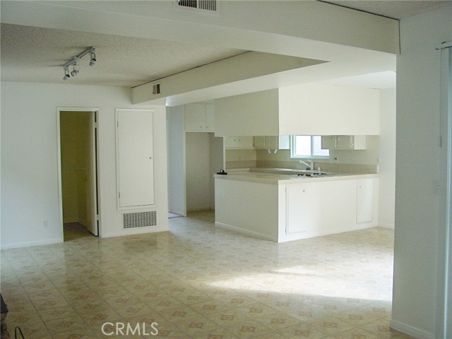 This shot is from the laundry area back toward the kitchen showing the dining area, kitchen, family room and the door to the downstairs half bath.