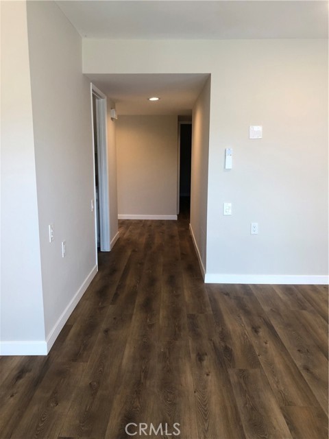 Hall entrance from the living room and dining area, going towards the foyer and bedrooms.