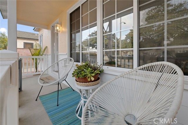 A nostalgic front porch on a tree-lined street with wide sidewalks