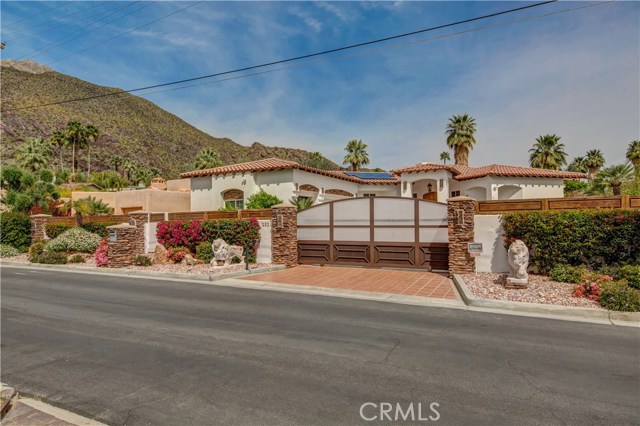 232 W Overlook Road Palm Springs, California Enter through a gated driveway to this stunning custom built Mediterranean style 4 Bedroom, 3 1/2 Bath entertainment home including Casita located in the historic and prestigious "Mesa" neighborhood nestled up against the backdrop of the San Jacinto Mountains. Beautiful double door front entry, a spacious Living Room with Fireplace and access via double glass doors to resort style backyard. The Media Room has a stunning Rose wood paneled entertainment center and raised Fireplace with Marble surround. The light, bright, gourmet Kitchen features beautiful Granite counters w/ tile backsplash, custom cabinetry, desk area, storage galore, great center island w/ Viking cooktop, Dining area, view and access to backyard via glass doors. Spacious Master suite has access to backyard via glass door, double sink vanity with Granite Counters, separate tub and shower, and large closet with built-in cabinetry and window. There are two additional main house Bedrooms, one of which has office area and huge closet, a hall Bathroom w/ double sink Granite counter vanity, hall guest Bathroom, large Laundry room w/ sink and access to a three car Garage with tons of storage space. Ten foot ceilings, stained concrete and tile floors keep this house cool and easy to keep. There is a light, bright, private detached Casita, amazing Pool, Spa, Waterfall, outdoor Fireplace, misting system, gated areas which can be perfect dog runs, beautiful landscaped yards, owned Solar and much more!