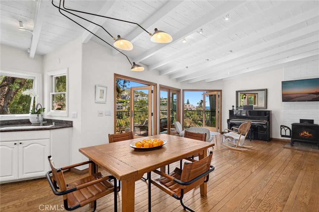 Exceptional location! Ideally situated near Laguna Village, this home offers serene ocean and canyon views on an oversized homesite of approximately 12,017 sq ft in a prime area of Laguna Beach. Experience tranquility, privacy, and natural beauty in this thoughtfully designed residence. The bright, open interior is just blocks from Laguna’s coves, beaches, restaurants, and shops. With approximately 2,522 sq ft, the three-bedroom, two-and-a-half-bath layout provides flexible living and entertaining options, enhanced by unobstructed canyon and ocean views. Designed with a clean, organic modern aesthetic, the kitchen features high-end appliances and a prep sink, opening to a living area filled with natural light. A freestanding Danish iron gas fireplace anchors the room, creating a warm and inviting atmosphere. The main level offers wide frontage that captures the surrounding views, while multiple expansive decks create seamless indoor-outdoor flow that is perfect for entertaining guests—complemented by a level yard with space for a potential in-ground spa. Downstairs, two bedrooms are separated by a secondary living space with surround sound that is perfect for a media room and has direct access to a spacious deck. The primary suite on this level includes outdoor access, a private deck, and a luxurious spa-like retreat bathroom with Carrera marble that opens to a courtyard featuring a fire pit and fountain water feature to enhance your relaxation. A third bedroom and a large laundry area on the lower level provide convenient access to the landscaped grounds and offer a quiet space for creativity and productivity. Additional features include French limestone and a concrete vanity in the powder room, abundant natural light through multiple doors and windows, multiple outdoor areas to connect with nature, an attached garage, and a spacious driveway. This distinctive property offers a rare combination of privacy, scenic beauty, and proximity to Laguna Beach’s top-rated schools, vibrant village, art scene, and coastline—an exceptional opportunity in one of Southern California’s most desirable coastal communities. Well-suited for a second home or main residence.