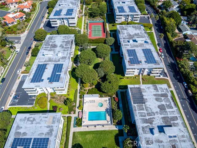 Aerial view of complex showing one of two tennis courts and second pool and spa in complex.