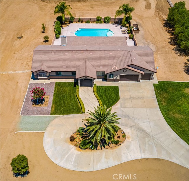 21850 Highland Street Wildomar, California Looking for large, FLAT horse property w/huge RV Garage, sparkling pool & spa, mountain views, upgraded 4BD-3BA & 4 car garage...then check out this ultimate single story pool home on 2.82 acres! This 100% useable lot is cleared & ready for your horses, livestock, RV, Boat, guest home & all of your toys! Offers fully enclosed RV Garage & workshop (apprx 24'x48') that has endless possibilities. This beautiful custom single story has an open floor plan, vaulted 12' ceilings (apprx), 9' doors (apprx), Plantation Shutters, built in shelving, exquisite tile flooring, custom fixtures & ceiling fans throughout. Offers Granite w/tile accents in the kitchen & all bathrooms. Has formal Dining Room, large Living Room, separate Family Room w/fireplace & large bedrooms (one w/Murphy bed). Dual Primary Suites have their own bathrooms, granite counters & dual sinks, walk-in closet & sliders to their own private porches. Gourmet Kitchen has plenty of cabinetry, granite counters, tile backsplash, stainless appliances, instant hot water & grand center island. Oversized 4 car tandem "finished" garage is perfect for the auto/motorcycle enthusiasts! Also, includes paved circular driveway, manicured landscape, dual gated entry, huge rear covered patio & custom hardscape w/fire pit. The Olympic Size pool & spa are the icing on the cake. All this w/NO H.O.A, low taxes, access to horse trails & prime Cul-De-Sac location! Must see to appreciate this beauty!