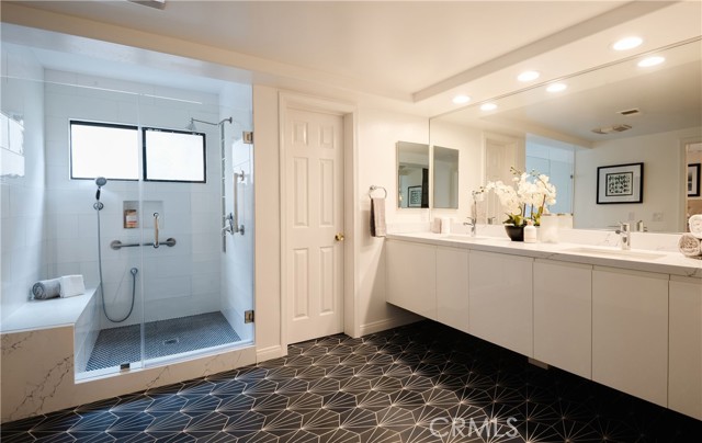 Primary bathroom with custom cabinets and quartz counters