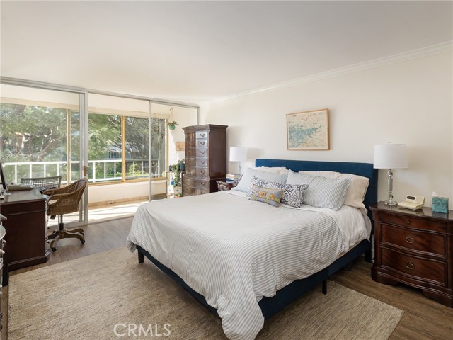 Primary bedroom has access to tiled deck that overlooks the serene and lush grounds of the complex.