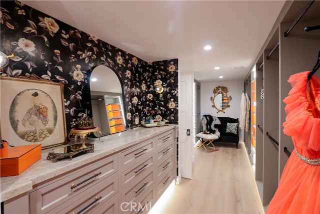 An exceptional dressing room style primary closet with extensive custom storage, a striking Onyx countertop and thoughtfully designed space for every wardrobe essential.\n