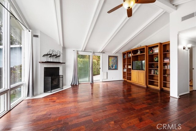 Open and bright large living room area with wood burning fireplace and open beam ceilings