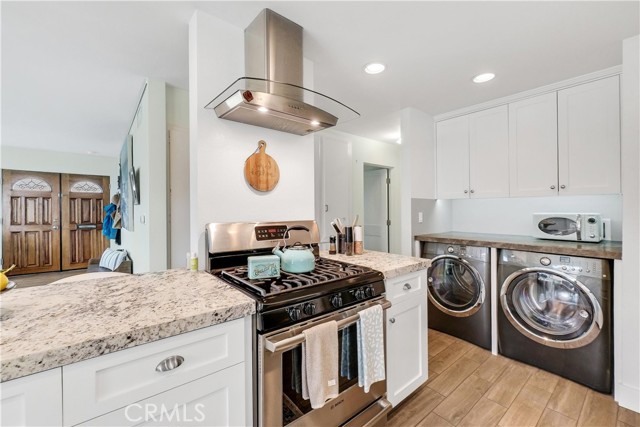 A 5 burner gas stove and beautiful laundry area with stone countertop