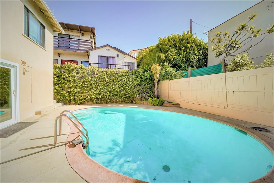 The full sized pool is surrounded by nice landscaping and trees