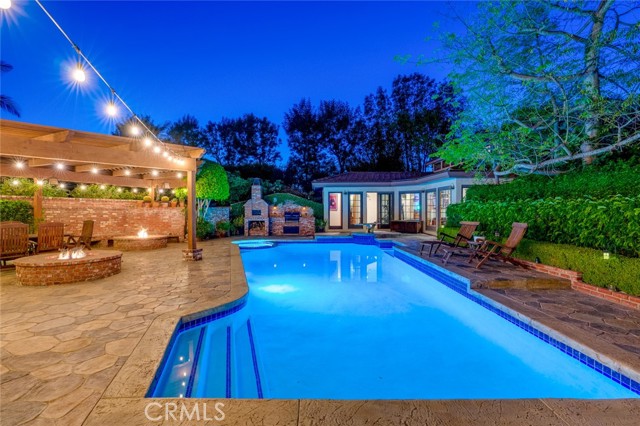 This gorgeous one-of-a-kind 5 bedroom, 4 bath home is tucked away on a quiet cul-de-sac in Yorba Linda. The incredibly manicured front entry is one you must see to believe, offering custom brickwork, twin waterfalls, and a custom Koi Pond. Showcasing 3,817 sq. ft. of space there are many wonderful features of this residence. The living room is accented with new paint, new lighting, and views of the lush garden. Built-in cabinets, vaulted beamed ceilings, a large brick fireplace, and a built-in wet bar round off the living and dining rooms. A custom-built kitchen is the heart of this home and features all new Stainless-Steel appliances and countertops covered in Italian Quartzite. The large center island can provide seating for up to six. Plenty of storage is provided by the custom solid oak cabinets and lots of natural light illuminates the space through two large overhead skylights. The kitchen opens to the upper yards through a sliding door. The primary bedroom suite has an attached office, large walk-in closets, an in-ceiling speaker system, and opens to an ensuite bathroom. Relax after a long day in the custom spa tub or in the large open rain shower. The remaining secondary bedrooms have all been recently painted and offer large closet space. The custom bar, which seats up to eight guests, accesses the ultimate experience of entertaining guests outside of the home. The main patio has two large firepits with custom brick seating. Enjoy swimming in the pool or relaxing in the jacuzzi. Gather around the pool area and cook up something to eat at the built-in pizza oven or four-burner BBQ. The adjacent 575 sq. ft. pool house comes complete with a bathroom, pool table, and home gym. A lower half-acre plus grassy yard includes winding pathways, a half basketball court, and a craft shop with additional storage. On the far end of the lower yard is a smaller garden and chicken coop. This property is rated for horses. Additional features include a 50-year tile roof and paid solar panels. Great schools, new shopping, and the city center are all located nearby. Come and discover this home today!