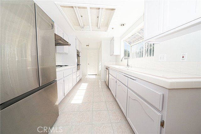 Kitchen with full bath ahead and attached garage to the left and laundry area to the right