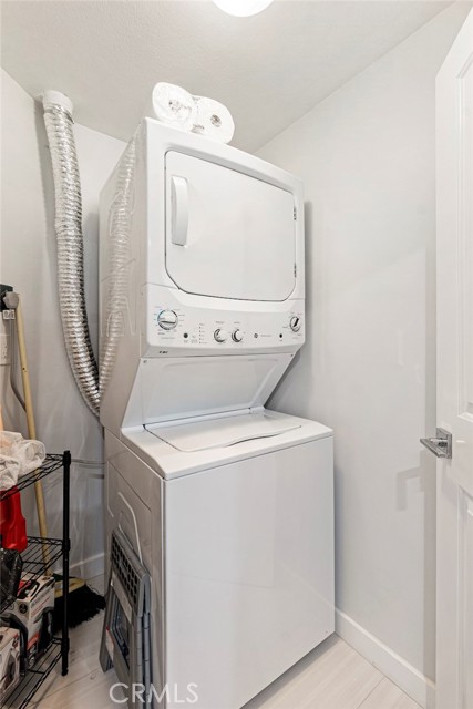 Separate laundry room with stackable washer/dryer