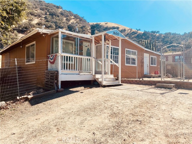 Front of home with deck & parking area.