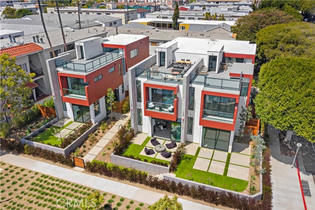 1329 California Avenue 102 Santa Monica, California The award winning, William Adams, has created another architectural masterpiece. This much anticipated north of Wilshire, new construction townhome is now available. Every angle of this home has been artistically rendered. The landscaping creates a palette of color and warmth and has been strategically planted to create intimate spaces while still being close to it all. Sunlight moves throughout the home like art work, reflecting off the perfect mix of glass, warm redwood and fine industrial finishes. From curbside to rooftop, this home is a stunner. Walking through the expansive glass entry door you’ll be wowed by the dramatic lines and open concept this home delivers. Flooded with natural light- the main level hosts a high end kitchen with Miele appliances and Bulthaup cabinets.The kitchen is finished with an abundance of cupboards, drawers, and a kitchen island accented with a walnut toned breakfast bar. A thoughtfully designed custom pantry with butcher block counters offers plenty of additional storage. Gallery worthy walls, recessed lighting, concrete floors in a terrazzo style add to the warm industrial modern vibe of this Santa Monica townhome. A modern corner fireplace warms the living and dining spaces. Glass telescoping doors open to a private use front patio which extends the living space to the outdoors. Both the patio and expansive rooftop deck are plumbed for gas, allowing flexibility while entertaining and grilling. The mezzanine offers additional entertaining space. A few steps above the mezzanine is the primary bedroom. Located at the front of the home, it’s adorned with a private balcony and walk-in closet. The primary bathroom is a delight with gorgeous floating, walnut toned cabinets, a large glass walled shower and separate tub. Two undermount sinks complemented with linear white quartz counters. A few steps up lies a spacious secondary bedroom and bathroom. The laundry area is located on this level as well as an open space, perfect for a home office or play zone. This space could also be converted to a 3rd bedroom. The large private rooftop deck rests one flight up. Boasting views of the surrounding area, this space provides an additional outdoor area to enjoy the Santa Monica weather. Further benefits of the home include a spacious attached two car garage with bike room, close proximity to Lincoln Middle School, custom automated shades and smart wiring throughout. This open concept masterpiece awaits you.