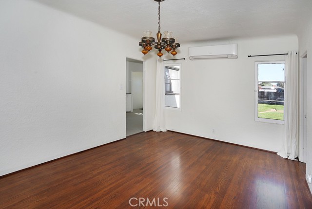 A vintage chandelier accents the large dining room. A mini split, professionally installed in 2021, is flanked by two windows over looking the back yard and allowing a very nice cross breeze.