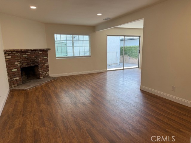 Family room with brick fireplace adjacent to the formal dining area and kitchen