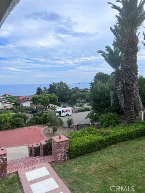 This is NOT an aerial drone photo, it is from the wrap around balcony to display the dramatic vantage point of the views. At the bottom of the stairs, past the driveway, you can see a brick parking pad for 2-3 vehicles. You can also see the security gate  directly across from the FedEx delivery vehicle.