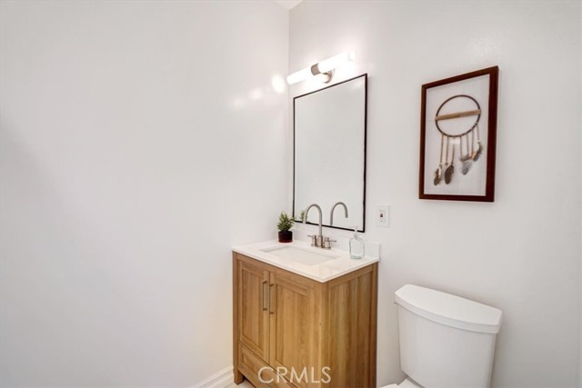 Hallway bath with new vanity, mirror, lighting fixture and toilet