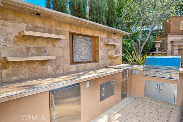 The outdoor kitchen complete with Lynx BBQ, side burner, sink and refrigerator. The decorative inset has also been used to house a flat screen TV.