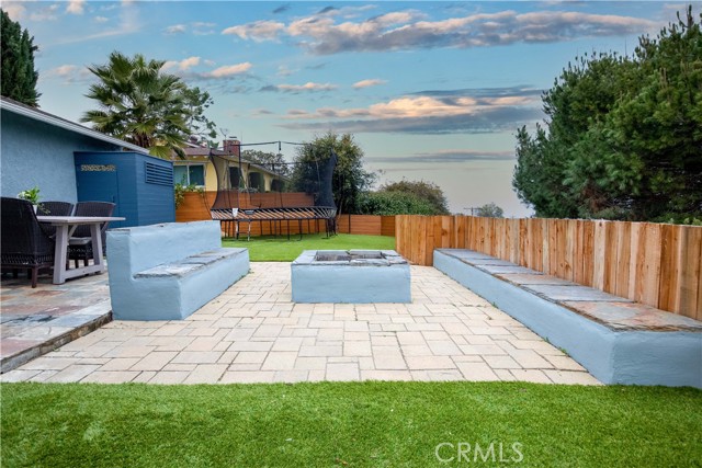 Awesome backyard with fire pit, bench, slate stone, and turf grass. There is a lower yard as well.