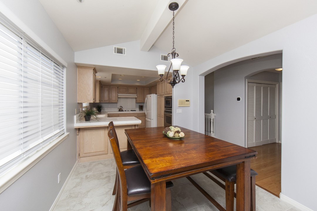 Dining area with high ceiling opens up to kitchen