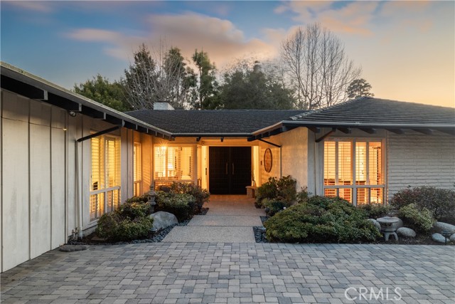 The refined and graceful landscaping at the entry invites you into the home.