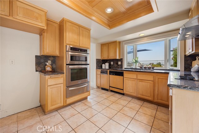 This kitchen offers plenty of storage cabinets, granite counters, and a beautiful bay window to enjoy everyday sunsets.